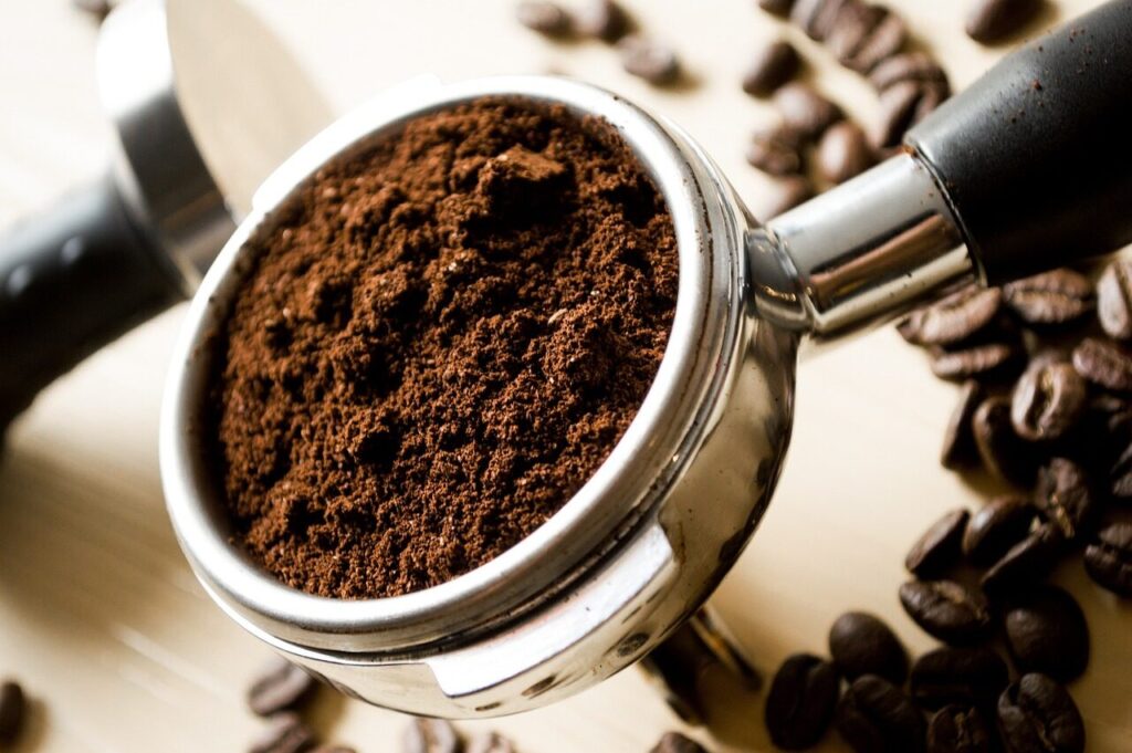 Coarsely ground coffee and water steeping together in a large glass jar