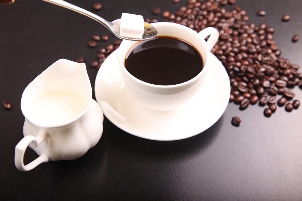 Dark coffee frozen in an ice cube tray beside a glass of coffee