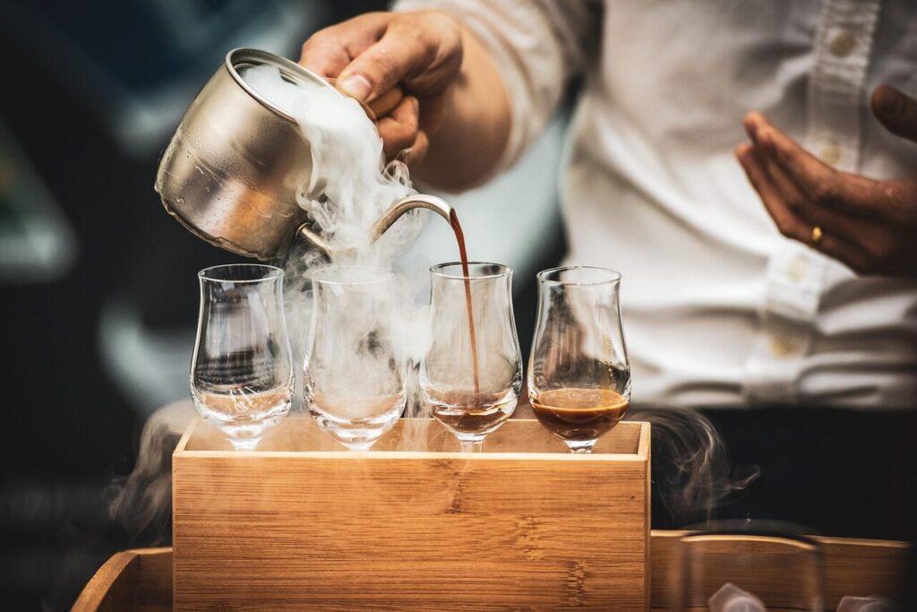 Glass jar of cold brew concentrate next to a filled glass with ice