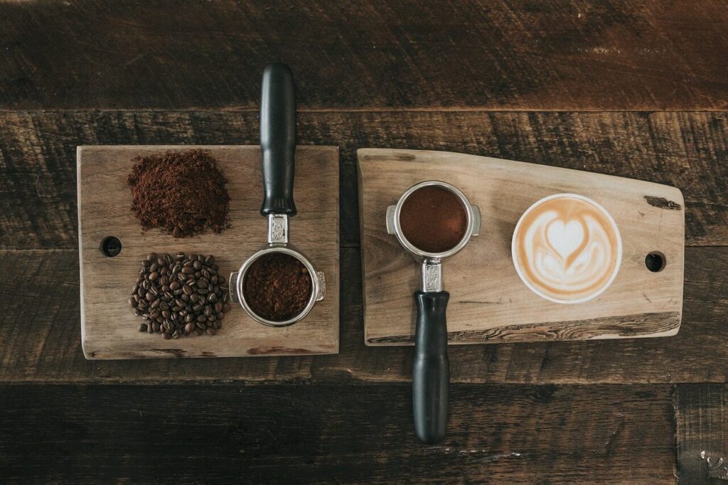 Spoonfuls of ground coffee arranged from fine to coarse on a wooden table